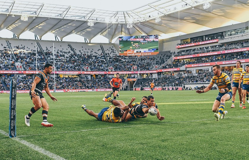 Corey Thompson dives over for a Wests Tigers try