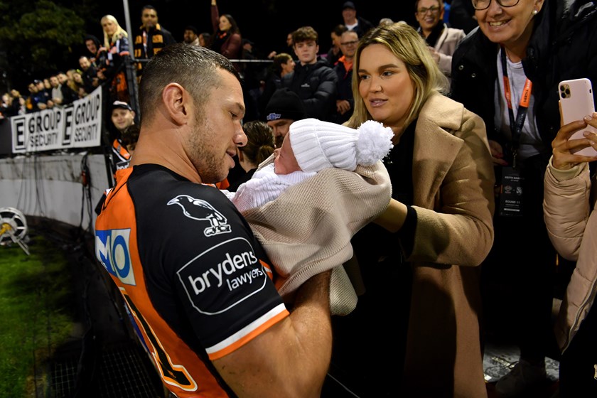 Naden cradling his newborn son with partner Eden after Wests Tigers debut at Leichhardt